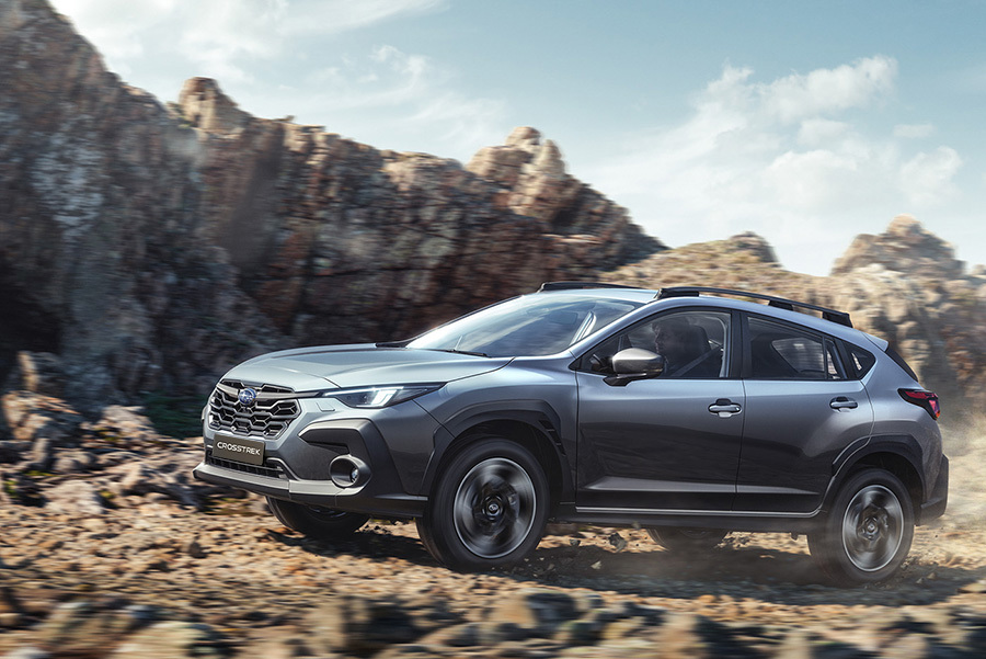 Subaru Crosstrek kører på en grusvej med støvskyer, der hvirvler op bag bilen.