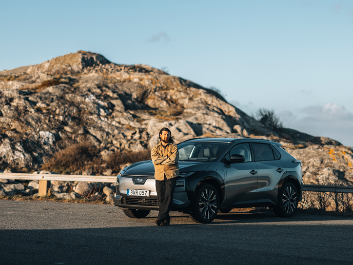 Subaru Solterra parkeret i et klippelandskab med en person foran bilen.