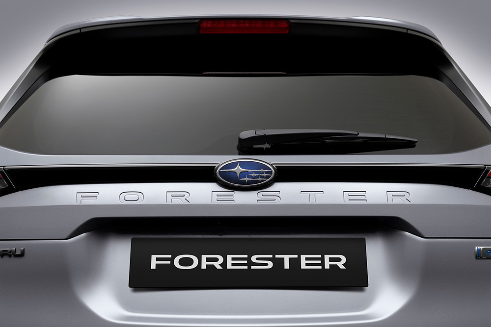 Nærbillede af Subaru-emblemet og den indgraverede Forester-logo på bilens bagklap.