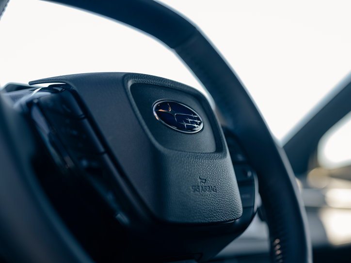 Nærbillede af Subaru-rat med Subaru-logo og SRS-airbag.